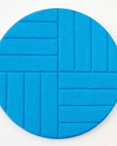 在椭圆形画布上是浅蓝色的水平和垂直条纹.