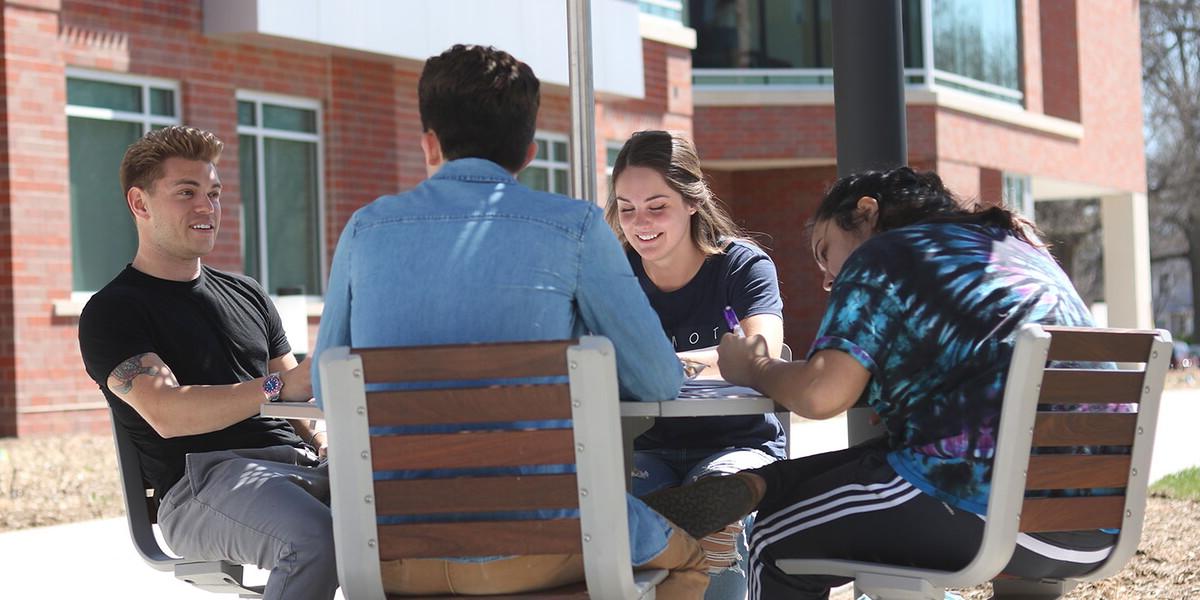 Four students outside studying together
